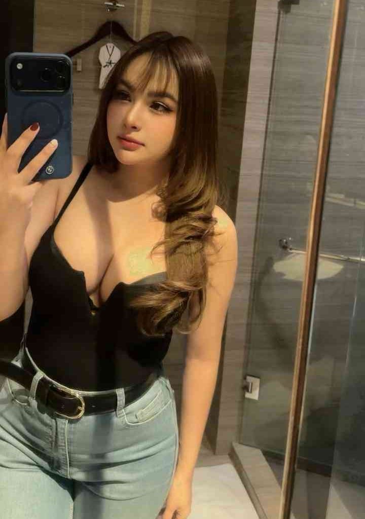 KL Escort Girl Young woman in a black top and jeans taking a selfie in a mirror. Escort Malay