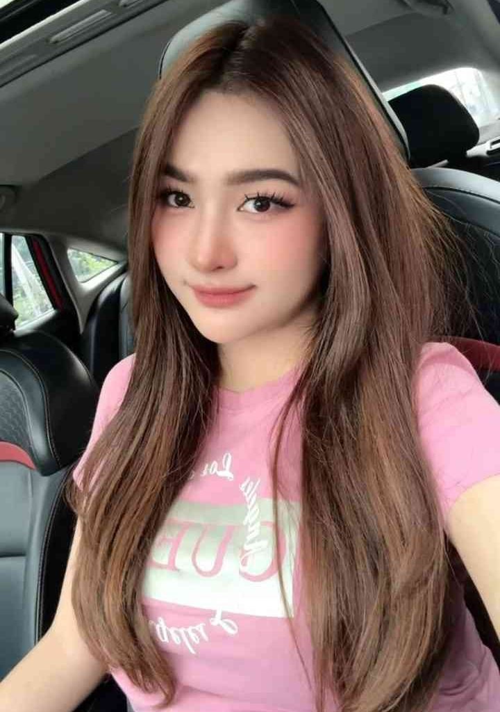 KL Escort Girl Young woman with long brown hair and pink shirt smiling in a car Escort Malay