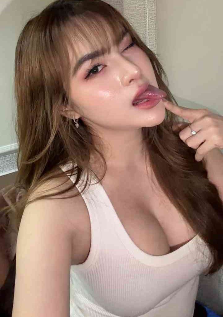 KL Escort Girl Young woman with brown hair and bangs, winking and sticking out her tongue. Escort Malay